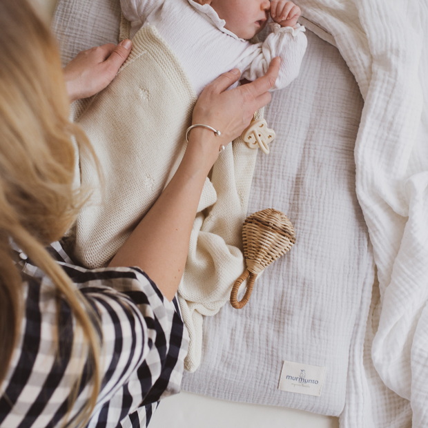 Baby liegt auf Bio-Wickelauflage