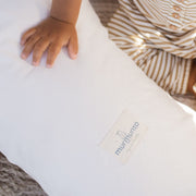 Baby sitzt neben Bio-Stillkissen